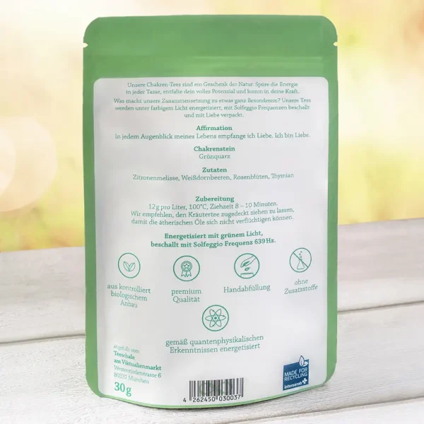 Rückseite der Verpackung des Herzchakra-Tees von Lich Schale. Enthält Informationen zur Affirmation: ‚In jedem Augenblick meines Lebens empfange ich Liebe. Ich bin Liebe.‘ Chakra-Stein: Grünquarz. Zutaten: Zitronenmelisse, Weißdornbeeren, Rosenblüten, Thymian. Zubereitungsempfehlung: 12 g pro Liter, 100 °C, 8–10 Minuten. Energisiert mit grünem Licht, beschallt mit Solfeggio Frequenz 639 Hz. Symbole für Bio-Anbau, Premium-Qualität, Handabfüllung, ohne Zusatzstoffe, quantenphysikalische Energetisierung.