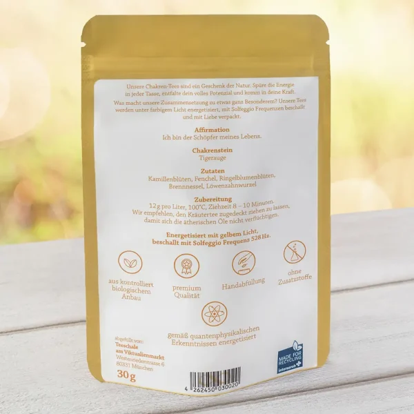 Rückseite der Verpackung des Solar Plexus Chakra-Tees von Lich Schale. Die Beschreibung betont die energetisierende Wirkung durch gelbes Licht und Solfeggio Frequenz 528 Hz. Enthaltene Affirmation: ‚Ich bin der Schöpfer meines Lebens.‘ Chakra-Stein: Tigerauge. Zutaten: Kamillenblüten, Fenchel, Ringelblumenblüten, Brennnessel, Löwenzahnwurzel. Zubereitungsempfehlung: 12 g/Liter, 100°C, 8–10 Minuten Ziehzeit. Symbole unten: Bio-Anbau, Premium-Qualität, Handabfüllung, ohne Zusatzstoffe, energetisiert nach quantenphysikalischen Erkenntnissen. Gewicht: 30 g.