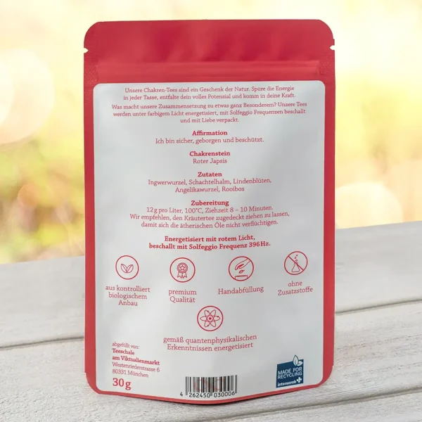 Rückseite einer roten Wurzelchakra-Tee-Verpackung mit Textinformationen zur Affirmation (‚Ich bin sicher, geborgen und beschützt‘), Chakra-Stein (Roter Jaspis), Zutaten (u.a. Ingwerwurzel, Lindenblüten, Rooibos), Zubereitungsempfehlung und Angaben zur energetischen Behandlung mit rotem Licht und Solfeggio-Frequenz 396 Hz. Unten Symbole für Bio-Anbau, Premium-Qualität, Handabfüllung und Verzicht auf Zusatzstoffe